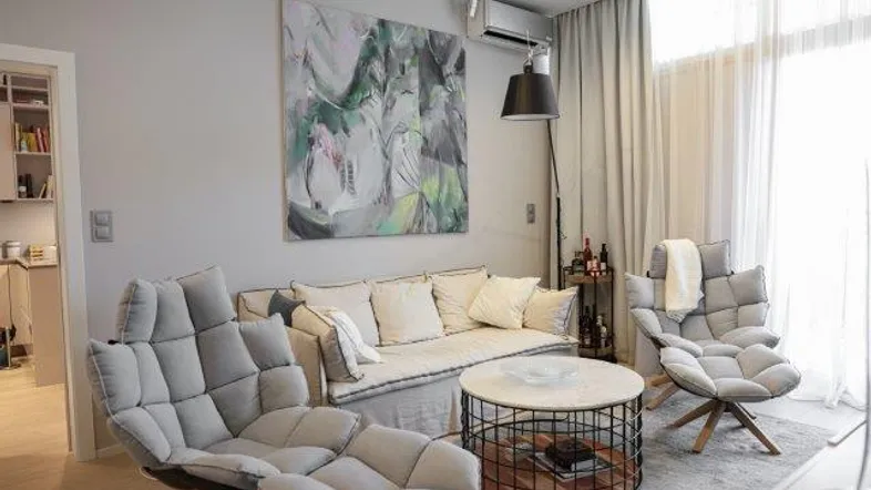 Helles Wohnzimmer mit bequemen Sesseln, Sofa und modernem Couchtisch, ideal zum Entspannen.