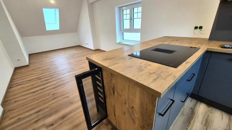 Moderne Küche mit Kochinsel, integriertem Weinkühler und Laminatboden im Dachgeschoss.