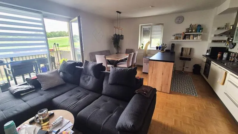 Geräumiger offener Wohn- und Essbereich mit moderner Küche und Zugang zum Balkon mit Weitblick.