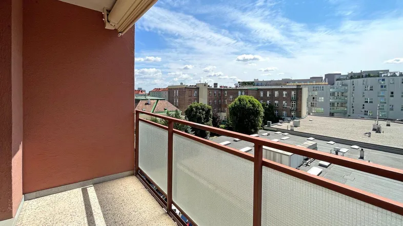 Heller Balkon mit Blick auf die umliegenden Gebäude und den blauen Himmel.