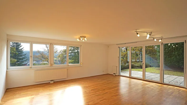 Wohnzimmer mit Fensterreihe nach Süden und Ausgang auf die Terrasse und in den Garten