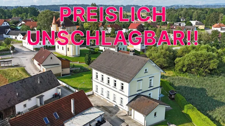 Luftaufnahme eines traditionellen Hauses in grüner, ländlicher Umgebung, beworben als 'PREISLICH UNSCHLAGBAR!!'.