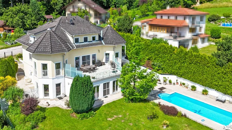 Luxuriöse Villa mit großem Garten, privatem Pool und weitläufiger Terrasse in grüner Umgebung.