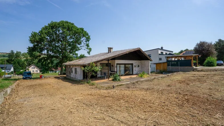 Freistehendes Haus mit Satteldach und großem Grundstück in ländlicher Umgebung.