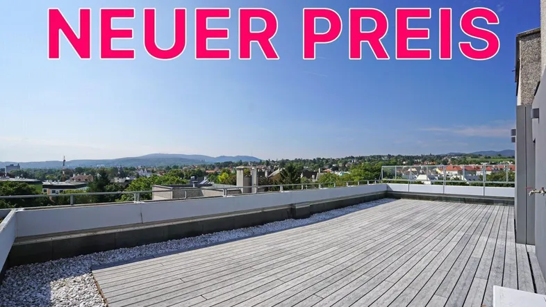 Große Dachterrasse mit Holzboden und weitem Blick über die Stadt und die umliegenden Berge.