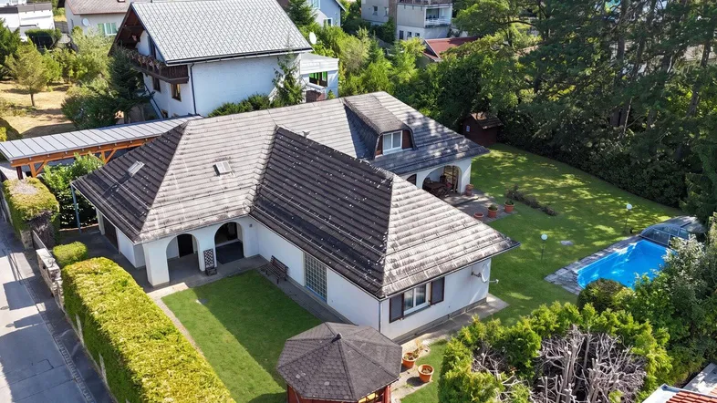 Luftaufnahme des Hauses mit großem Garten, Pool und umliegender grüner Landschaft.