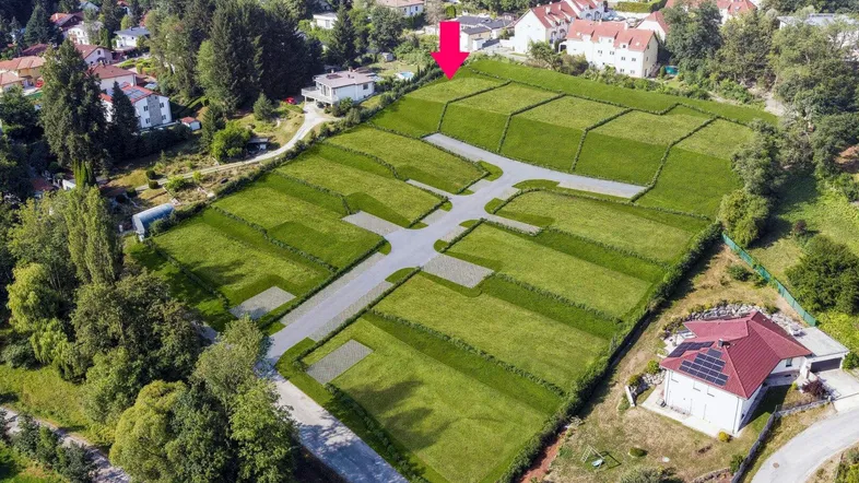 Luftaufnahme eines großen Grundstücks, das in mehrere Bauparzellen mit Wegen unterteilt ist.