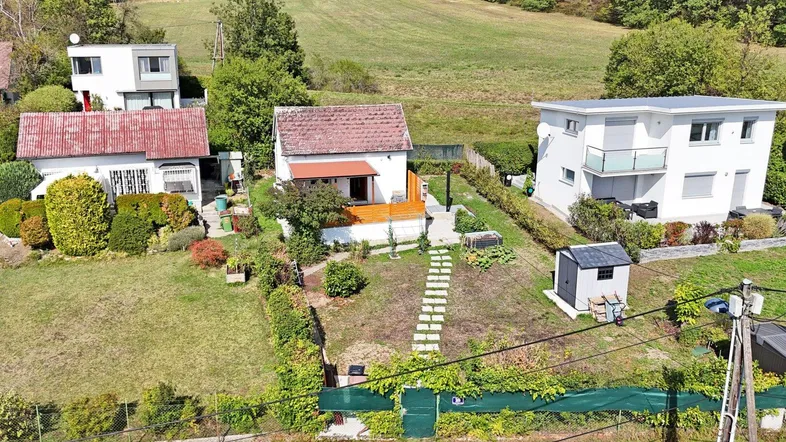 Luftaufnahme eines Hauses mit Garten und umliegender grüner Landschaft.