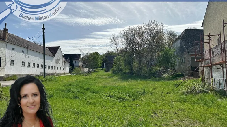 Großes, unbebautes Grundstück mit grüner Wiese und umliegenden Gebäuden in ländlicher Umgebung.