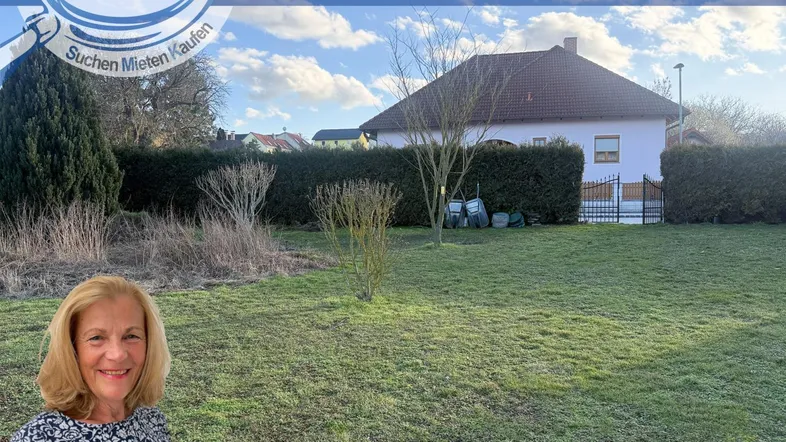 Gepflegter Gartenbereich mit Rasenfläche und Hecken, umgeben von einem Einfamilienhaus.