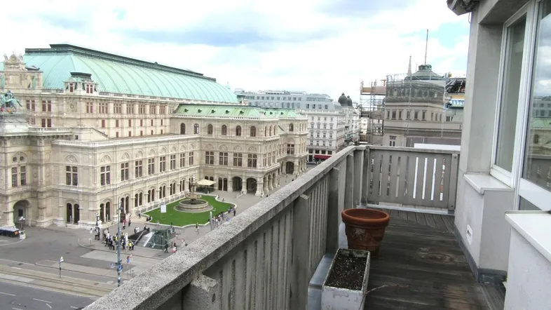 Geräumige Dachterrasse mit Holzboden und beeindruckendem Blick auf die Wiener Staatsoper.