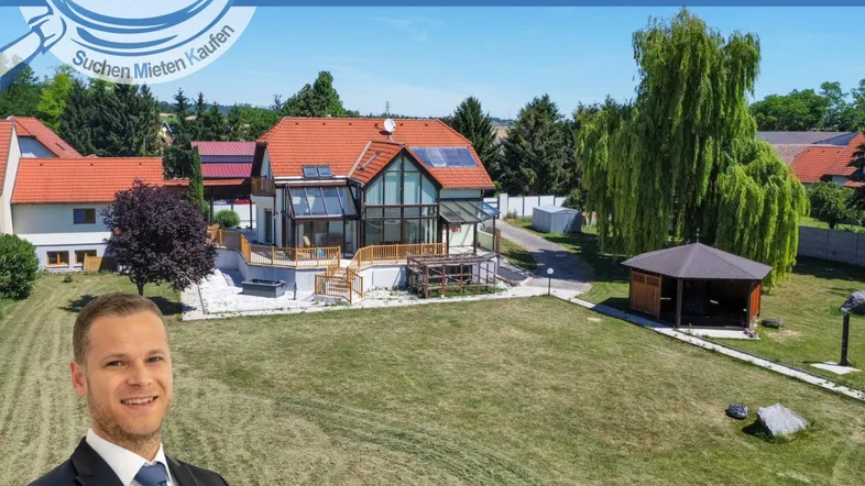 Großzügiges Anwesen mit weitläufigem Garten, Wohnhaus und Gartenlaube unter blauem Himmel.