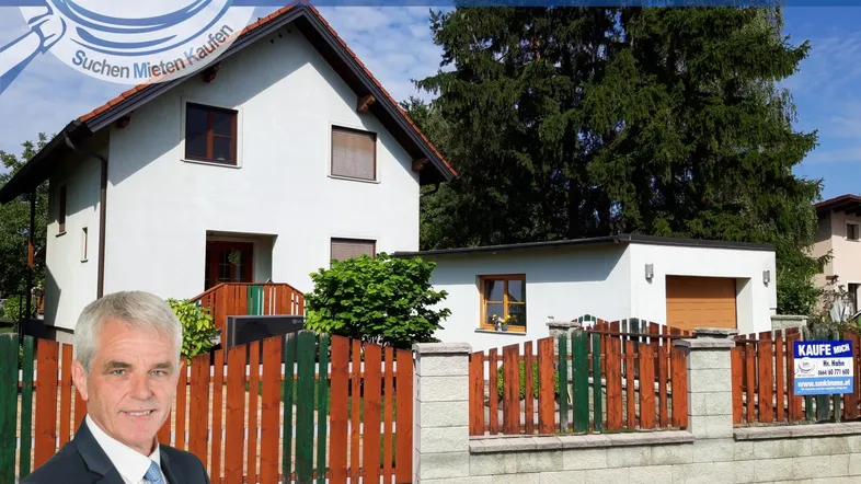 Helles Einfamilienhaus mit Satteldach, Vorgarten und Holzzaun in ländlicher Umgebung.
