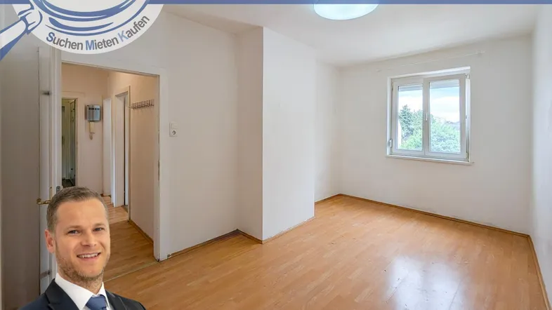 Heller Raum mit Holzfußboden und Blick ins Grüne, verbunden mit einem Flur.