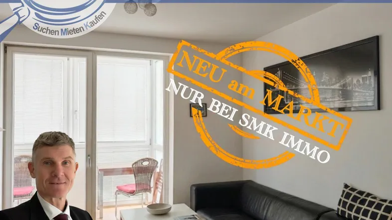Helles Wohnzimmer mit schwarzem Sofa, kleinem Couchtisch und Zugang zu einem Balkon oder einer Loggia.