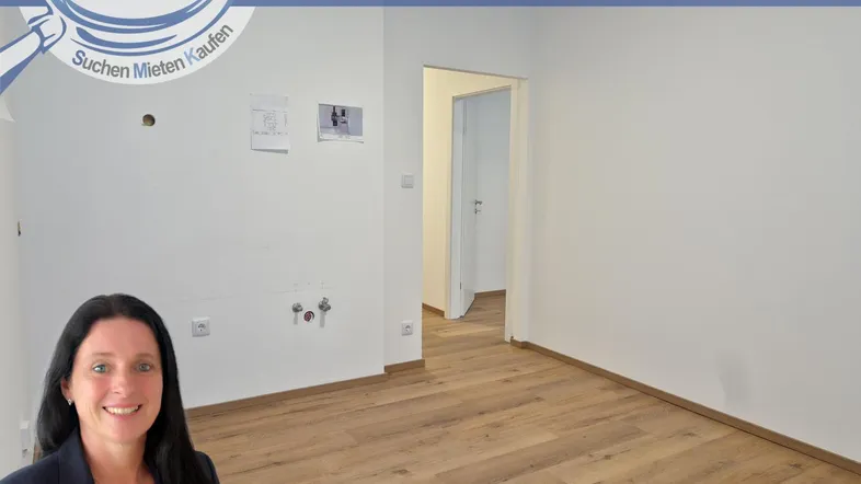Leerer Raum mit Anschlüssen für eine Küche und Laminatboden.