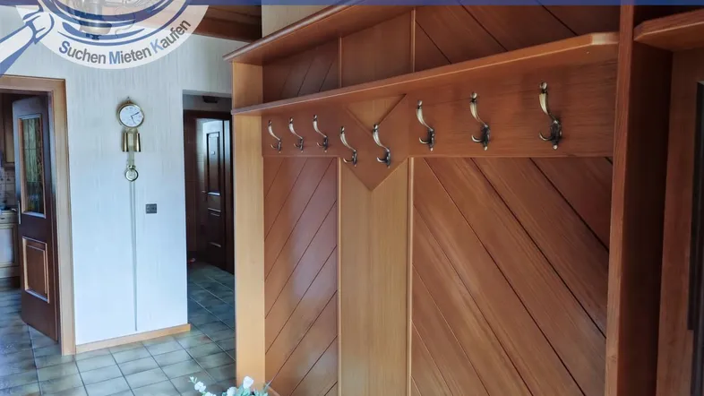 Traditioneller Eingangsbereich mit Holzvertäfelung, Garderobe und Fliesenboden, gut gepflegt.
