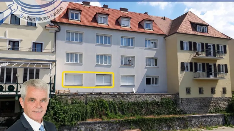 Mehrstöckiges Wohngebäude mit klassischer Architektur und gelb markierten Fenstern.