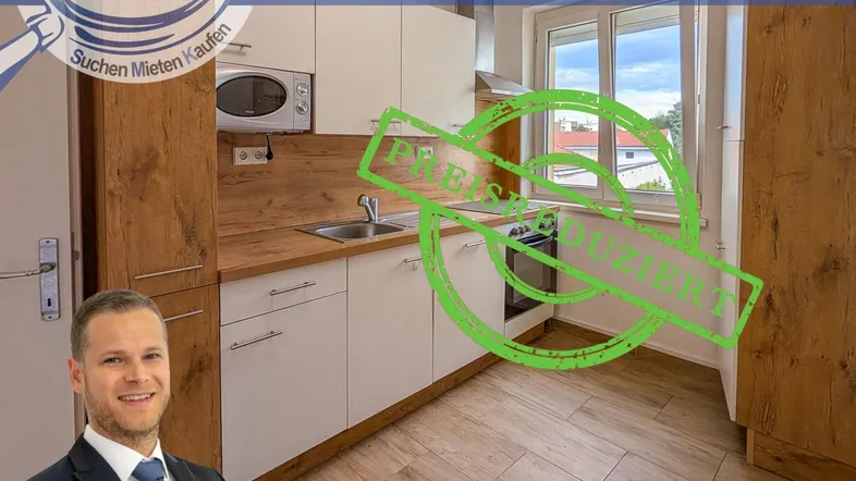 Kleine Küche mit Einbaugeräten, Holzoptik-Arbeitsplatte und Fenster mit Blick ins Grüne.