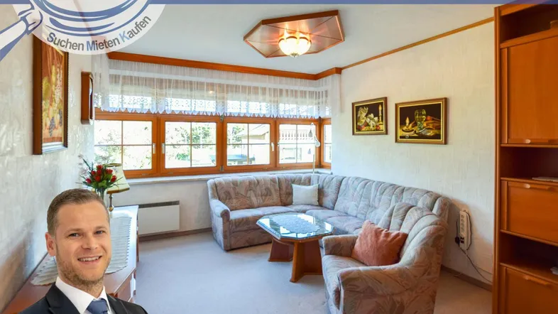 Gemütliches Wohnzimmer mit großem Ecksofa, Couchtisch und Blick ins Grüne durch die Fenster.