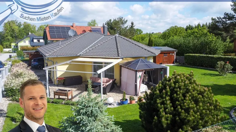 Ansicht des Einfamilienhauses mit gepflegtem Garten, überdachter Terrasse und einem Makler im Vordergrund.