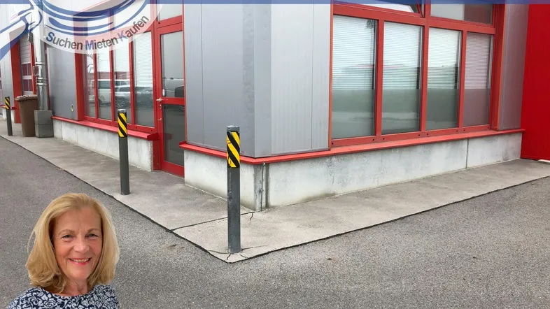 Außenansicht eines modernen Geschäftsgebäudes mit großen roten Fensterrahmen und einer Frau im Vordergrund.