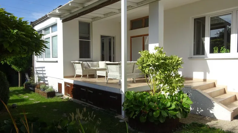 Überdachte Terrasse mit Gartenmöbeln und Blick ins Grüne, ideal für entspannte Stunden im Freien.