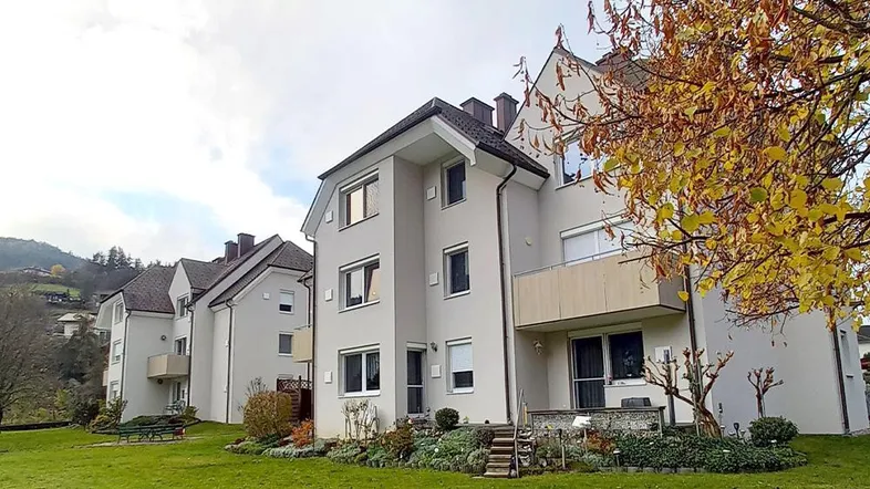 Mehrfamilienhaus mit gepflegter Fassade und großem Gartenbereich in ländlicher Umgebung.