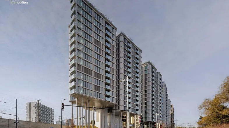Moderne Hochhäuser mit vielen Fenstern und Balkonen in urbaner Umgebung.