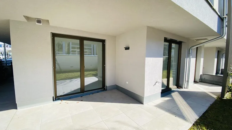 Geräumige Terrasse mit Fliesenboden und Zugang zu den Innenräumen, ideal für Entspannung im Freien.
