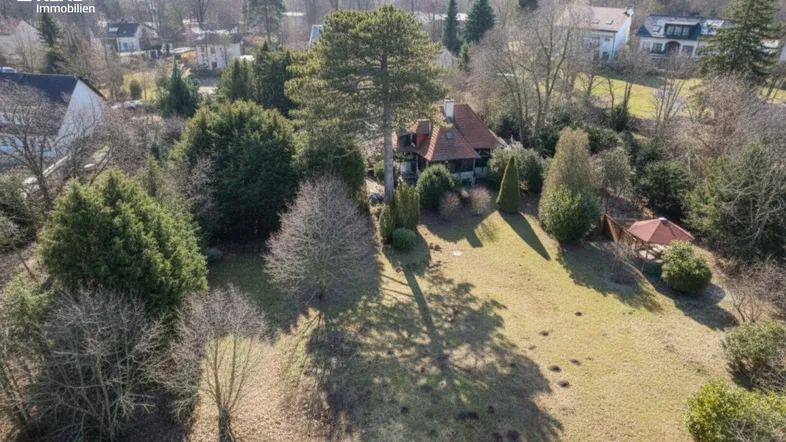 Luftaufnahme eines Hauses mit großem Garten und umliegender grüner Landschaft.