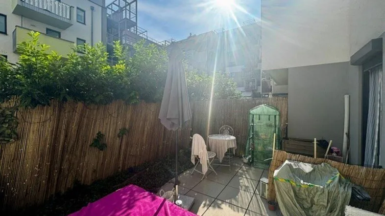 Sonnige Terrasse mit Sitzgelegenheiten, Liegefläche und Sichtschutz zum Entspannen im Freien.