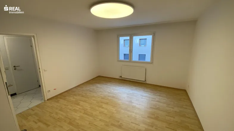 Helles Zimmer mit Parkettboden und weiß gestrichenen Wänden, bereit zur individuellen Gestaltung.
