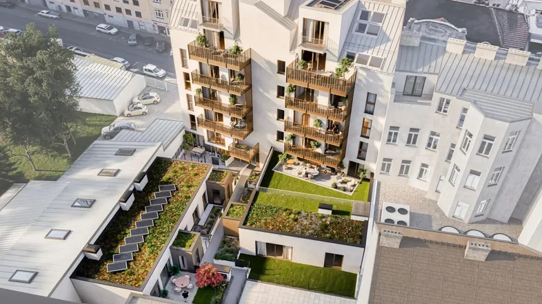 Luftaufnahme eines modernen Wohnkomplexes mit begrünten Dächern und zahlreichen Balkonen in städtischer Umgebung.