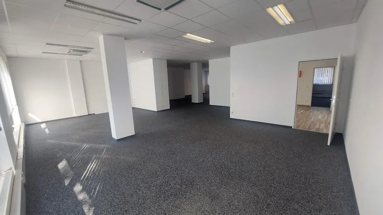 Geräumiges, leeres Büro mit Teppichboden und abgehängter Decke, bereit zur individuellen Gestaltung.