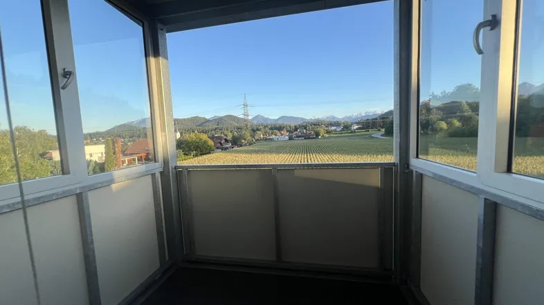 Verglaster Balkon mit weitem Blick über die Landschaft und die umliegenden Berge.