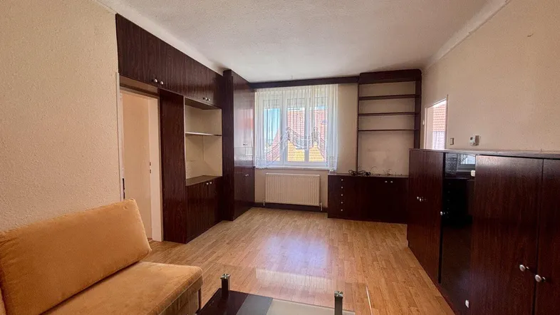 Wohnzimmer mit Holzfußboden, Sofa und Blick durch das Fenster.