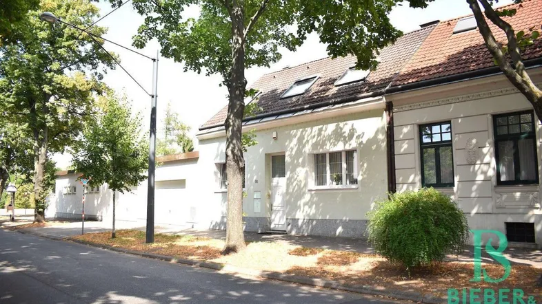 Ansicht des Hauses von der Straße mit Bäumen und Vorgarten, umgeben von einer ruhigen Wohngegend.