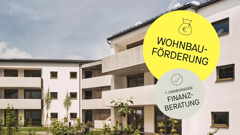 Moderne weiße Wohngebäude mit Balkonen und gepflegter Außenanlage unter blauem Himmel.