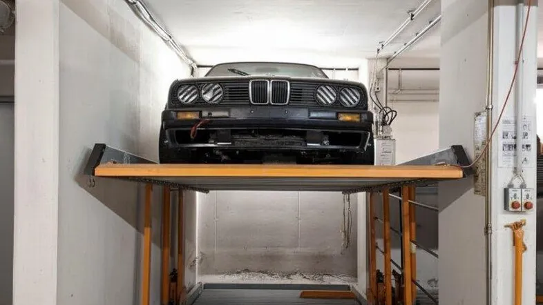 Tiefgarage mit modernem Doppelparker-System und einem geparkten Oldtimer auf der oberen Plattform.
