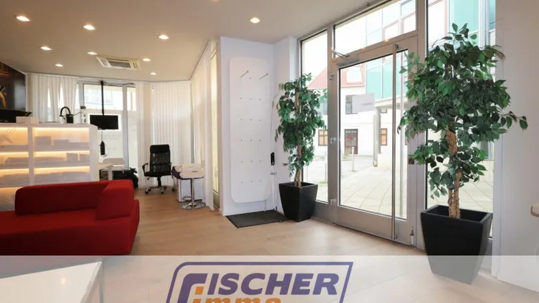 Heller Bürobereich mit moderner Einrichtung, großen Glasfronten und Zugang zu einem Innenhof.