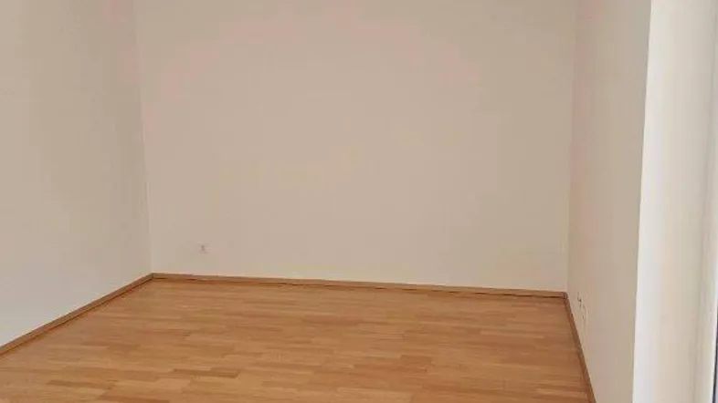 Heller, leerer Raum mit hellem Holzboden und weißen Wänden, bereit zur individuellen Gestaltung.