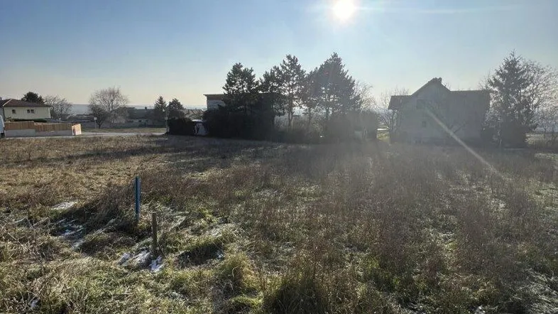 Weitläufiges Grundstück mit Blick auf die Umgebung und teilweise schneebedecktem Gras unter blauem Himmel.