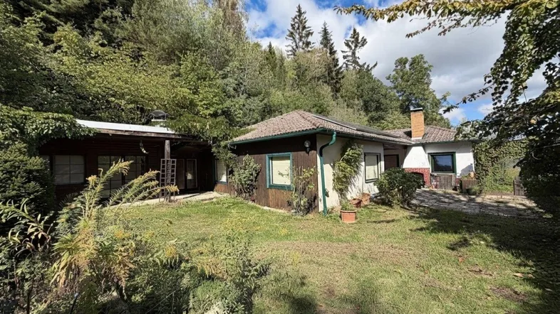 Freistehendes Haus mit großem Garten, umgeben von üppiger Natur und Bäumen.