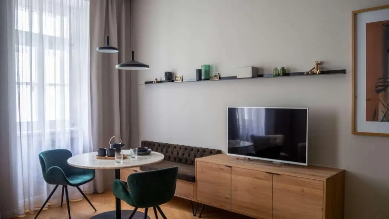 Helles Wohn- und Esszimmer mit modernem Mobiliar, Holzboden und großen Fenstern.