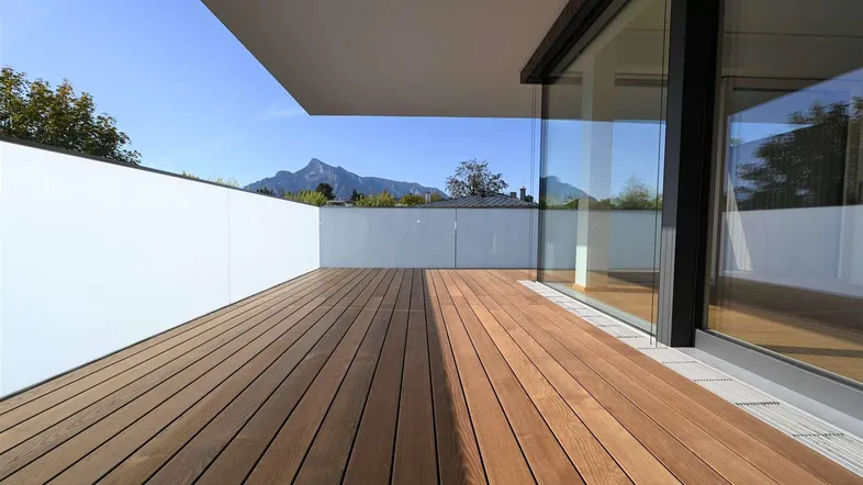 Große Holzterrasse mit weitem Bergblick und viel Sonnenlicht, ideal zum Entspannen im Freien.