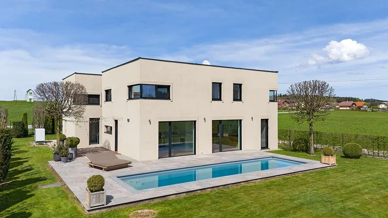 Modernes Einfamilienhaus mit Swimmingpool und weitläufigem Garten in ländlicher Umgebung.