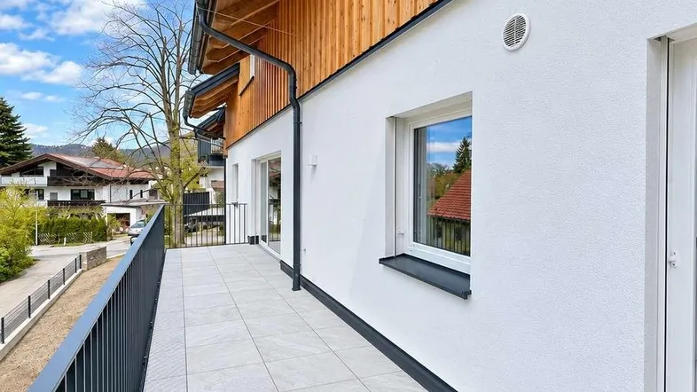Geräumiger Balkon mit Fliesenboden und moderner Metallbrüstung, ideal für entspannte Stunden im Freien.