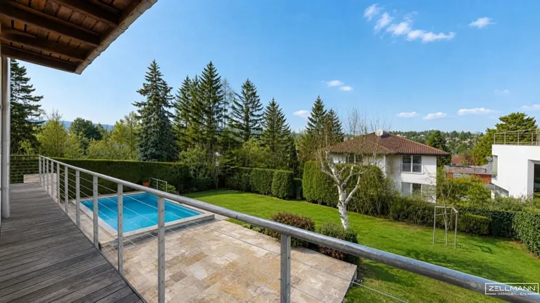 Geräumige Holzterrasse mit integriertem Pool und weitem Blick ins Grüne.