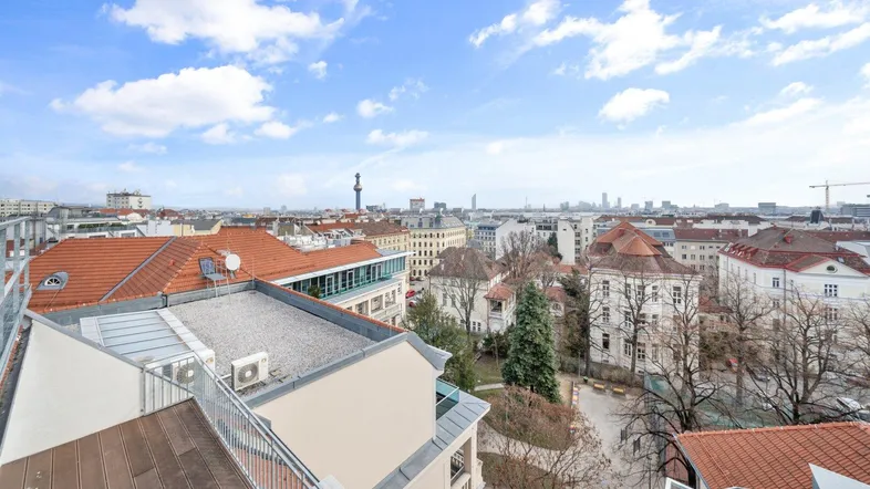 Weitläufiger Stadtblick über die Dächer Wiens mit Fernsicht auf die Skyline.